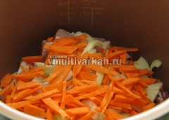 Выложите ребрышки, лук и морковь в чашу, готовьте 30 минут в режиме Выпечка