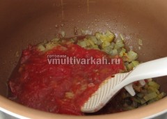 К луку добавьте перетертый помидор или томатную пасту и потушите
